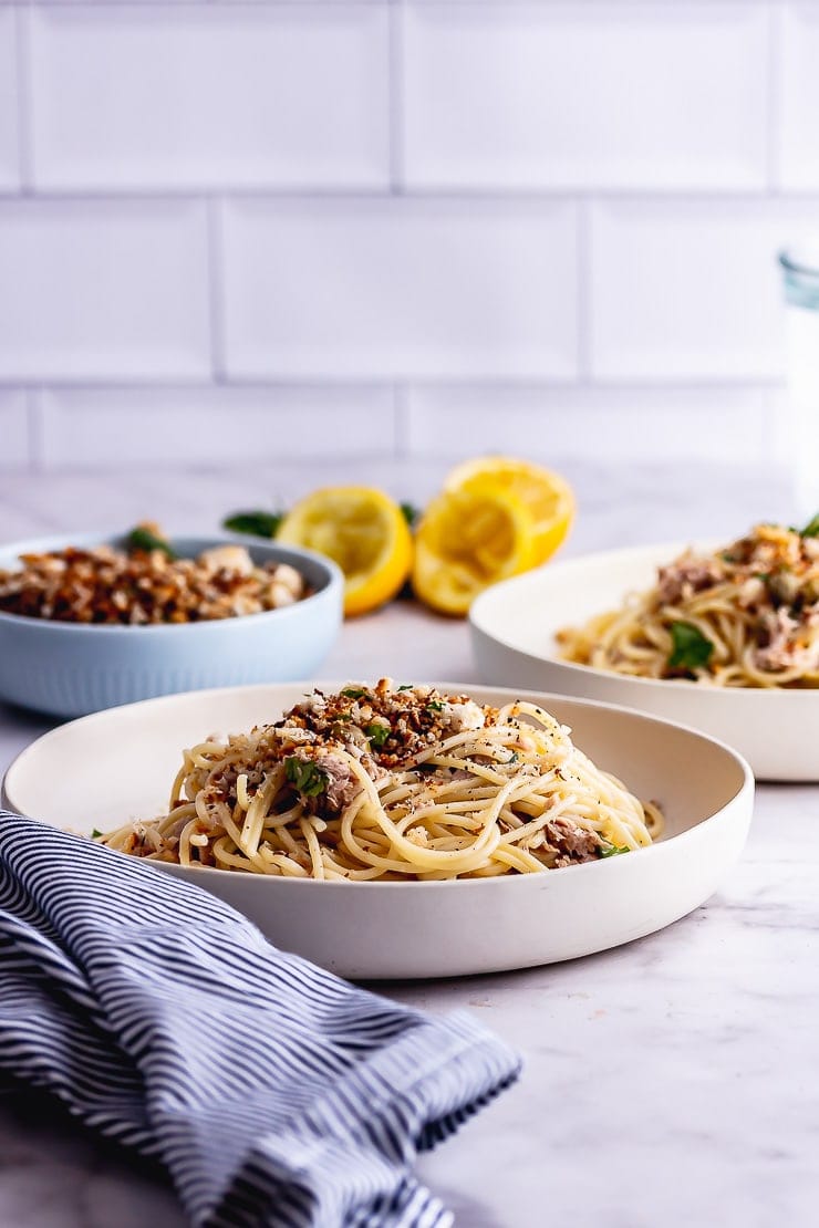 Side on shot of a bowl of tuna pasta with pangrattato on a marble surface