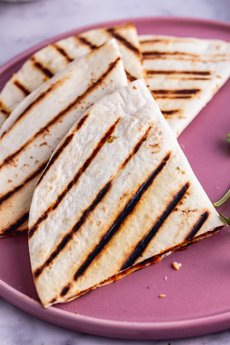 Close up of a vegetarian quesadilla on a pink plate