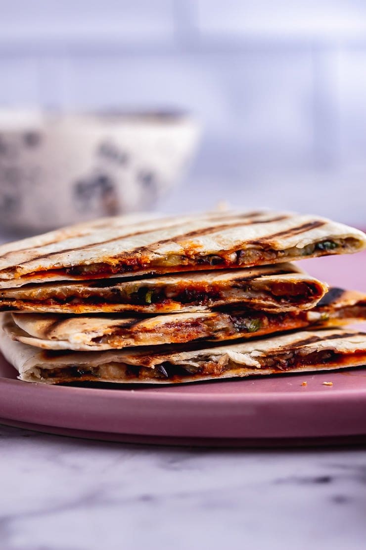 Stack of vegetarian quesadilla on a pink plate