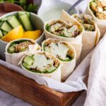 Veggie wraps in a wooden tray on a marble background