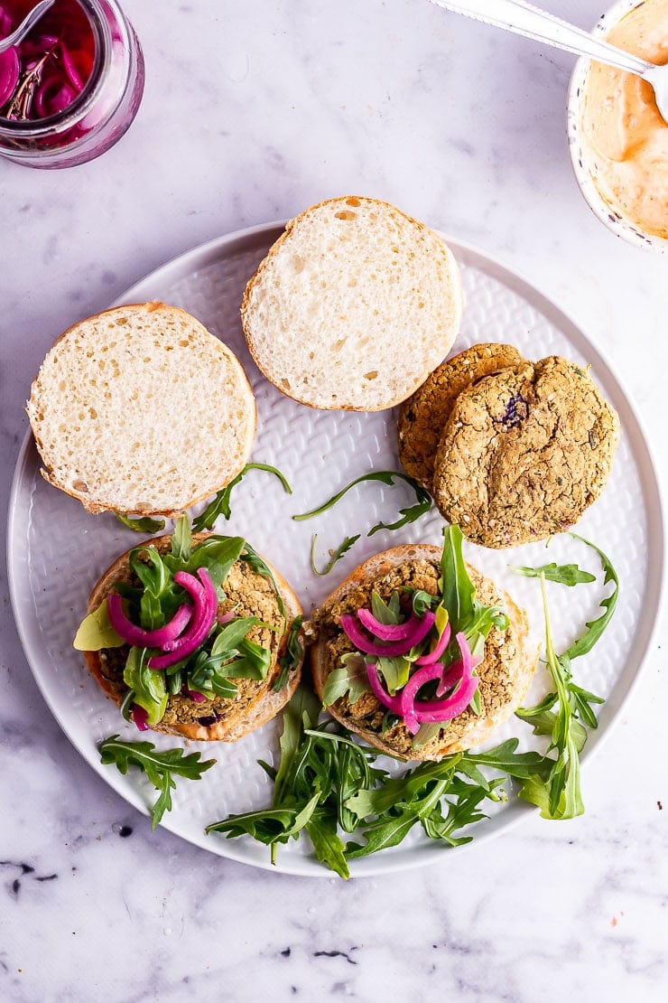 Overhead shot of baked falafel burgers on a grey plate over a marble surface