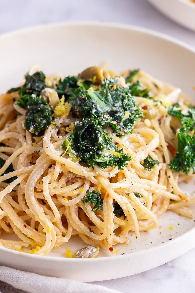 Close up of garlic spaghetti with kale in a white bowl