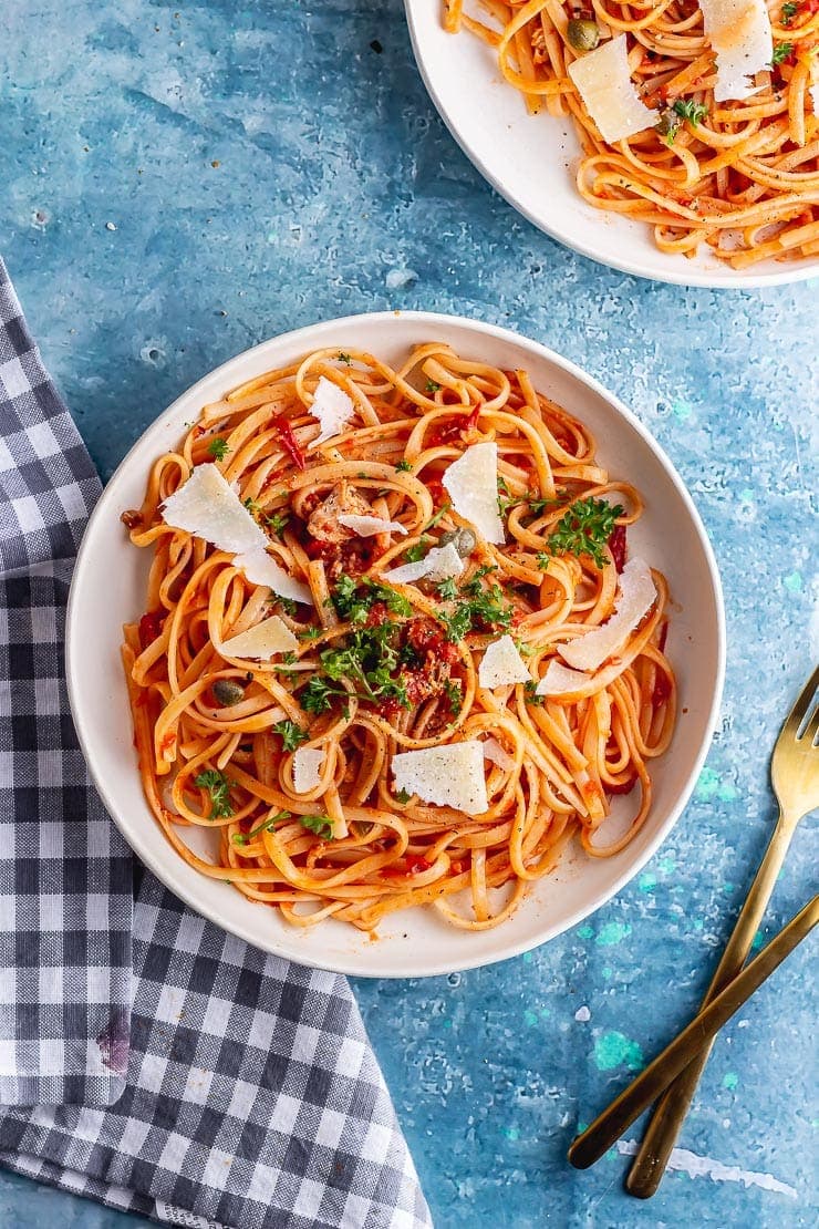 Overhead shot of spicy salmon pasta on a blue background