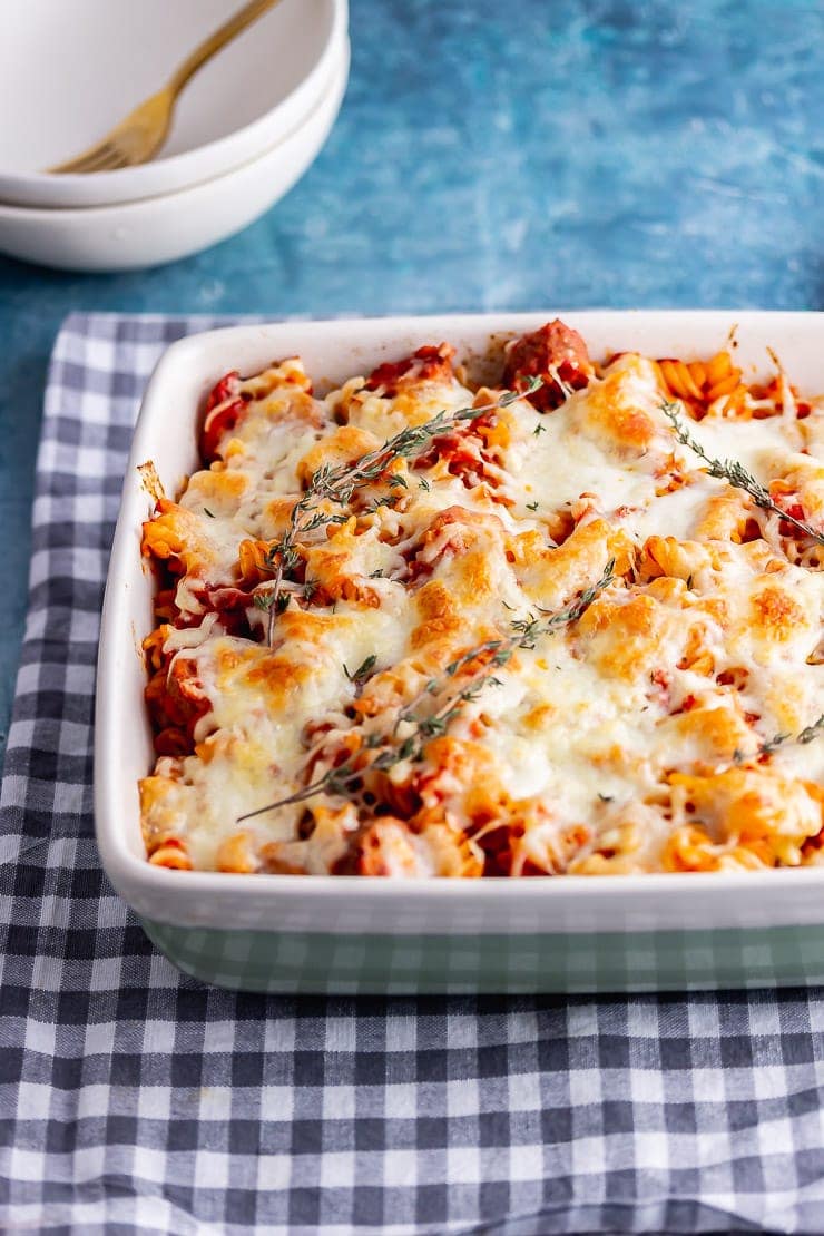 Vegetarian sausage bake in a green dish on a checked cloth