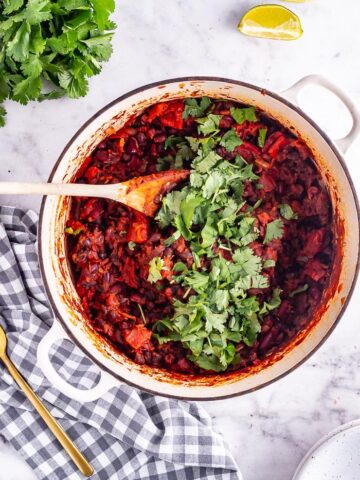 Overhead shot of bean chilli with coriander on a checked cloth