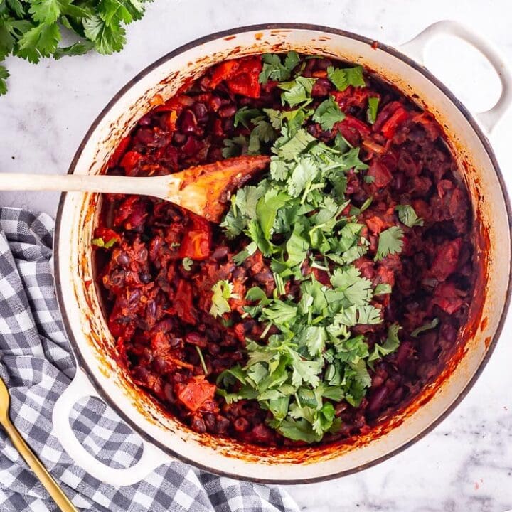 Overhead shot of bean chilli with coriander on a checked cloth