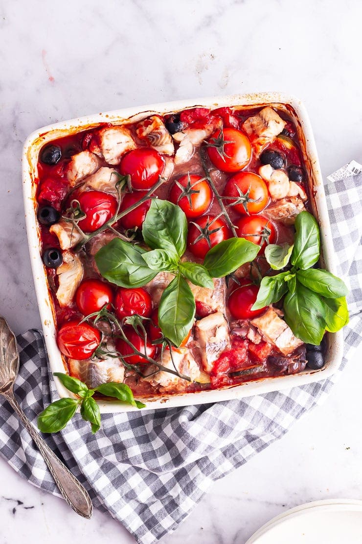 Fish and vegetable bake in a baking dish with a checked cloth