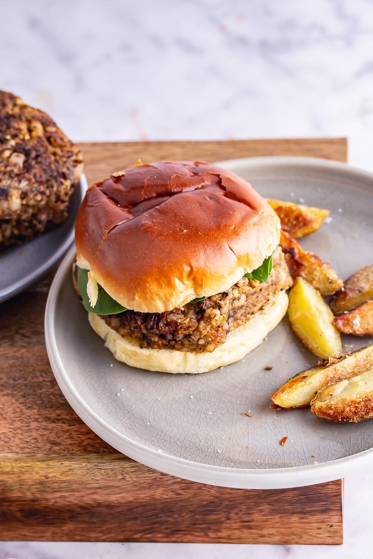 Mushroom burger with chips on a grey plate on a wooden box