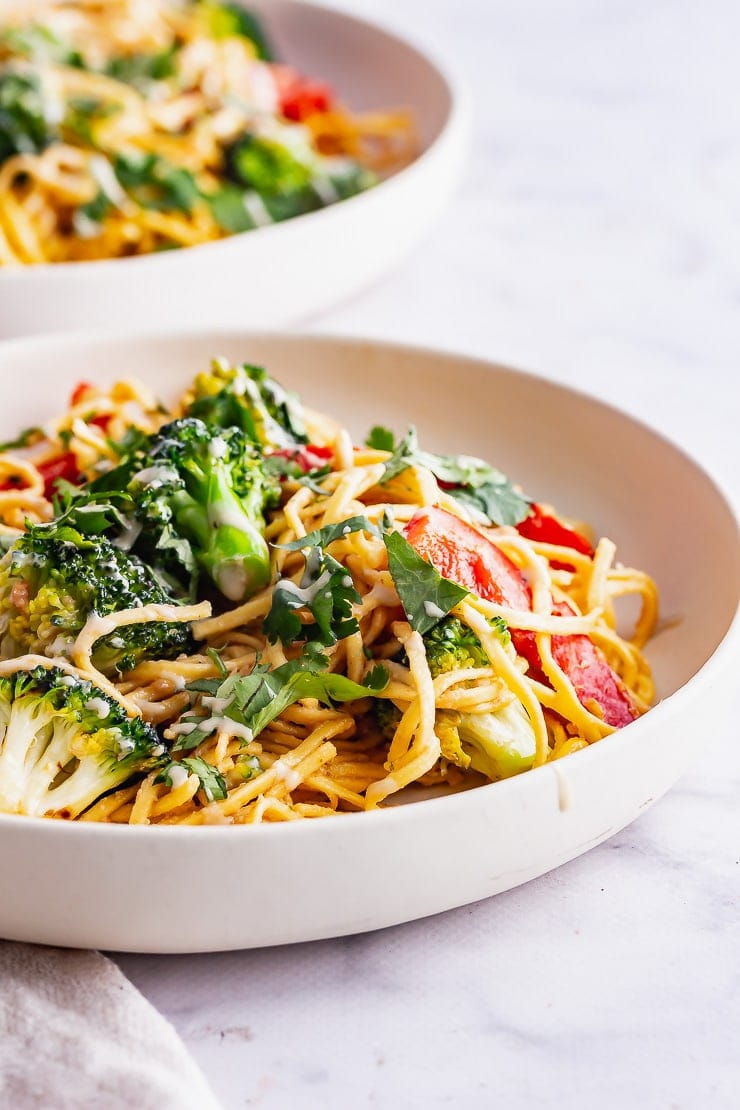 Side on close up shot of veggie noodle salad in a white bowl