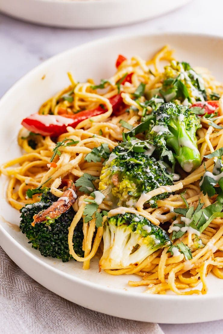 Close up of noodles with broccoli in a cream bowl