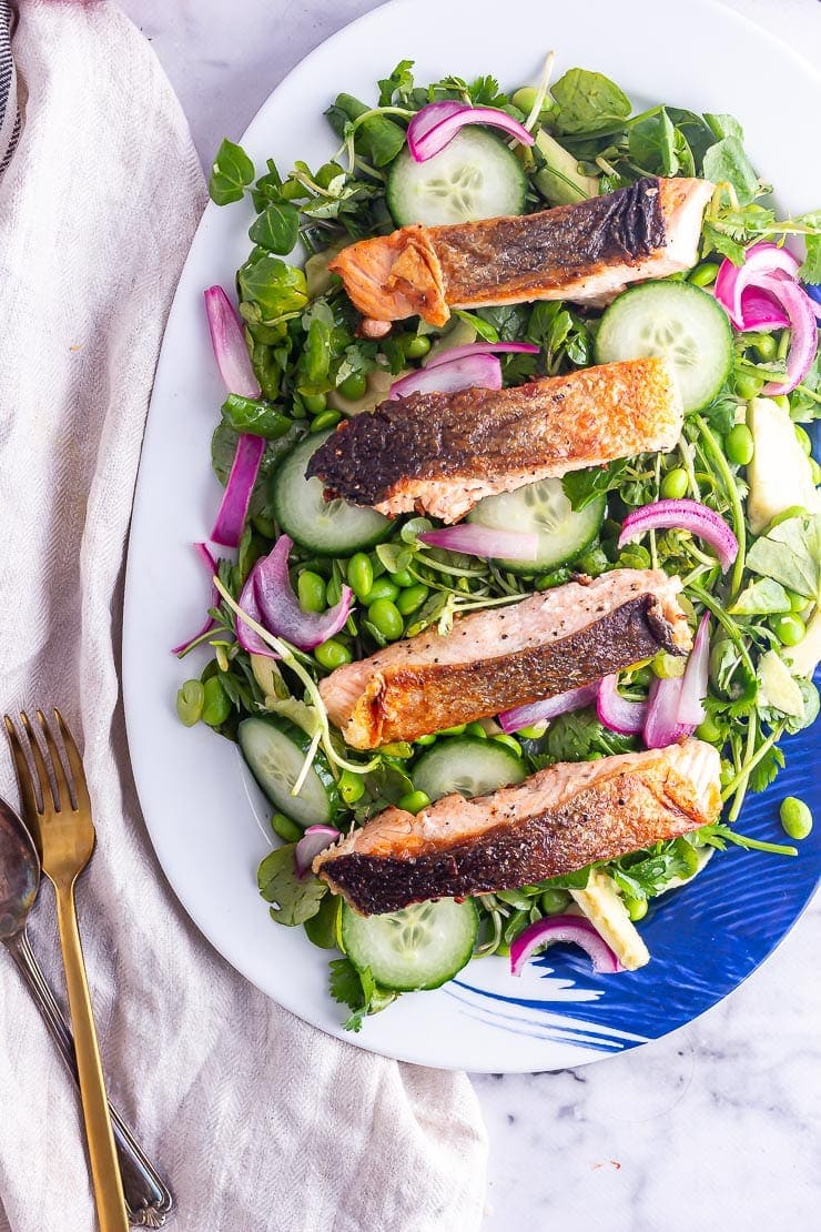 Salmon fillets on a salad with watercress and cucumber