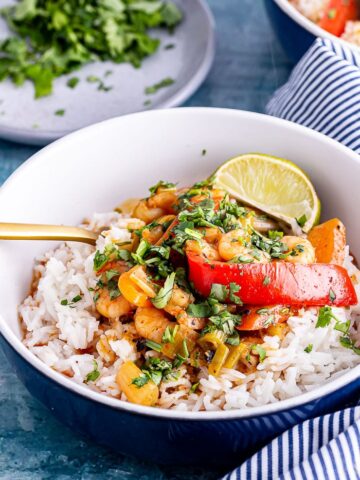 Close up of Thai prawn curry in a bowl with a gold fork