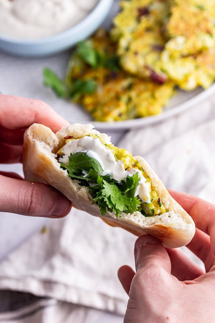 Cauliflower fritter in a pitta bread in two hands