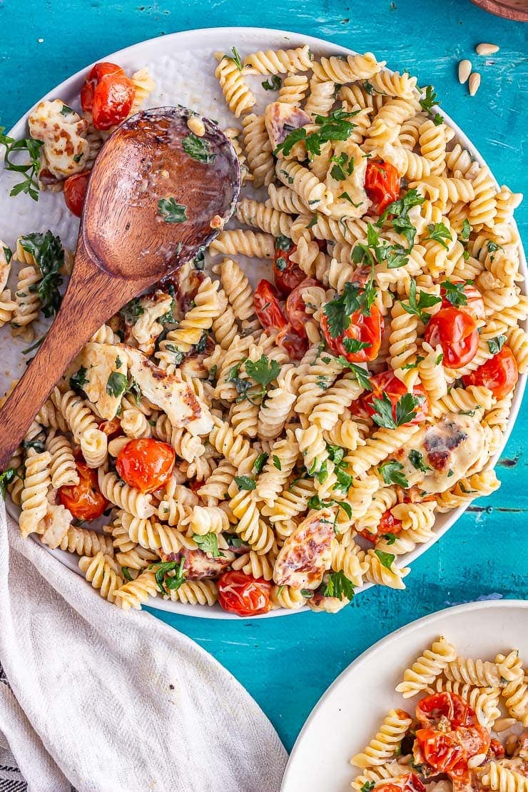 Platter of food on a blue background with a wooden spoon