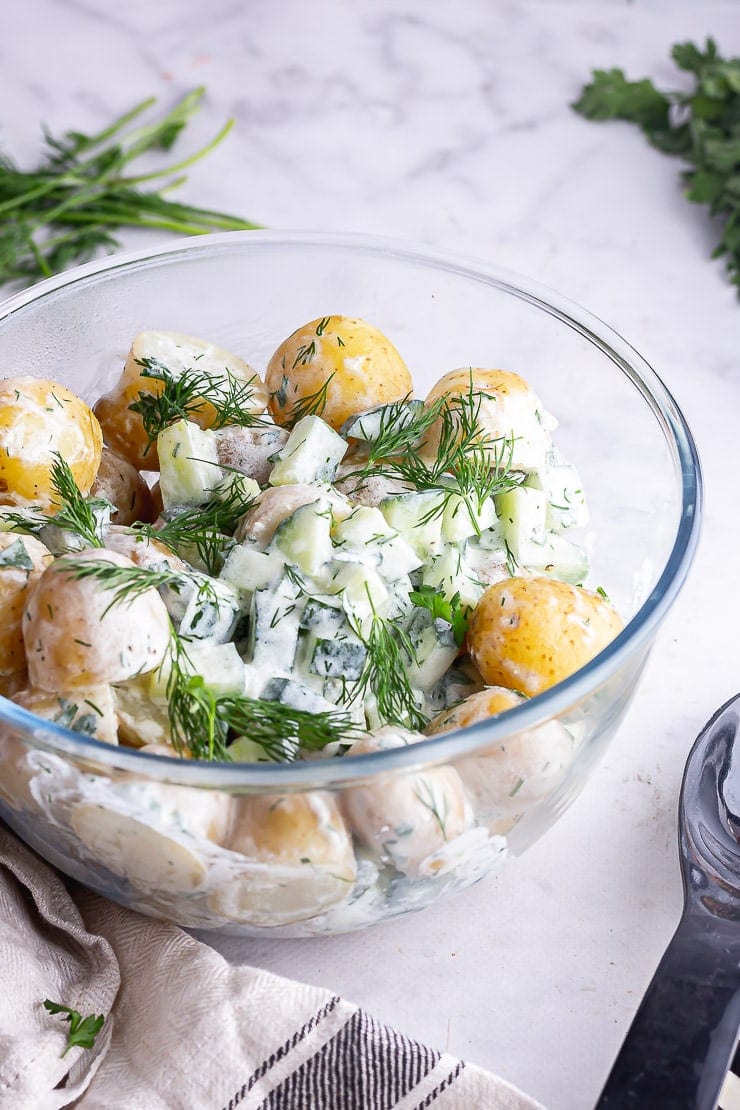 Side angle shot of healthy potato salad on a marble surface