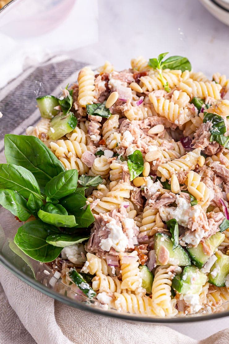 Tuna pasta salad in a glass bowl with basil