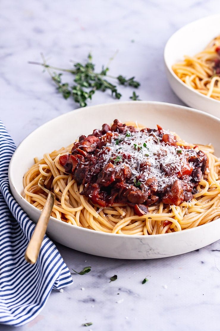 Side on shot of vegetarian spaghetti bolognese with parmesan and a gold fork