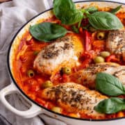 White skillet of Italian chicken with basil