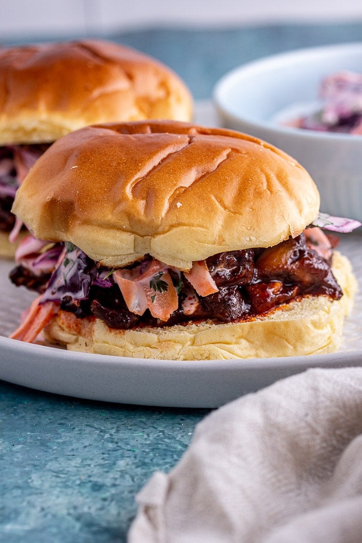 Close up shot of veggie pulled pork sandwich with slaw on a grey plate