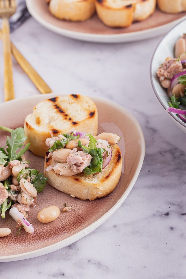 Garlic toasts with tuna bean salad on a pink plate