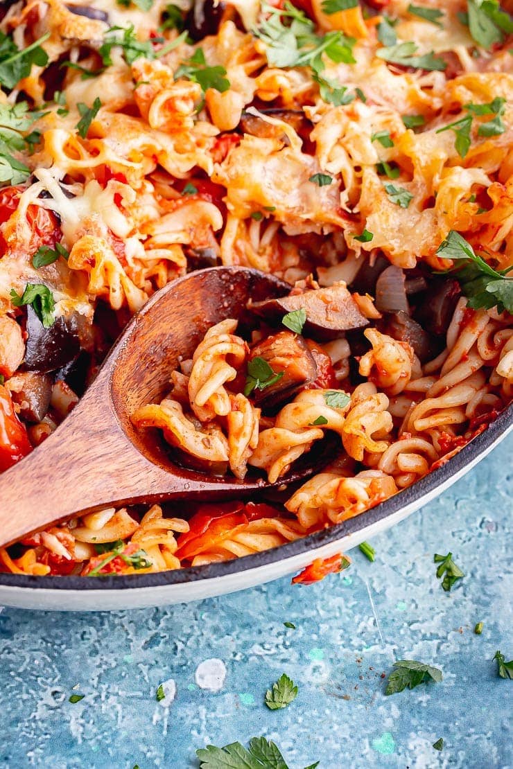 Close up of wooden spoon in veggie pasta with aubergine