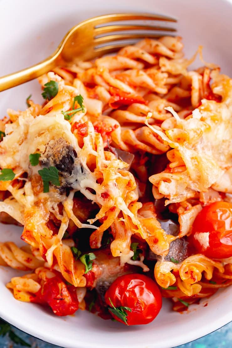 Close up of tomato pasta with cheese in a white bowl