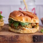 Tuna burgers on a wooden board over a marble background