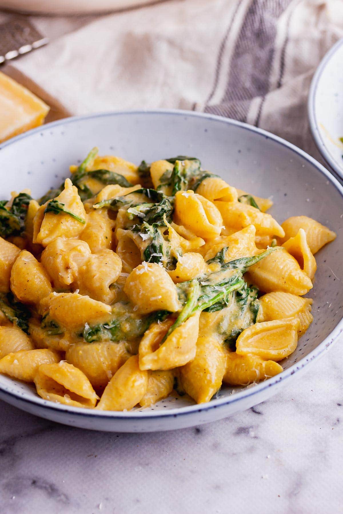Autumn pasta with spinach on a marble background