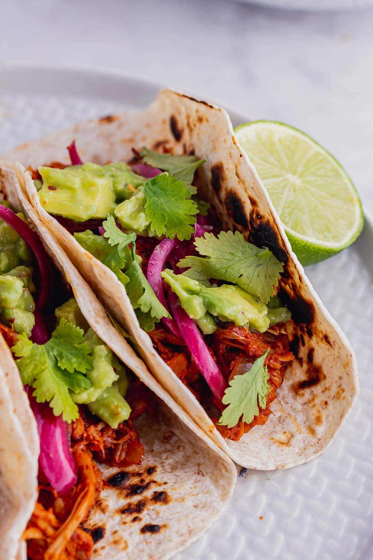 Close up of jackfruit tacos with lime and coriander