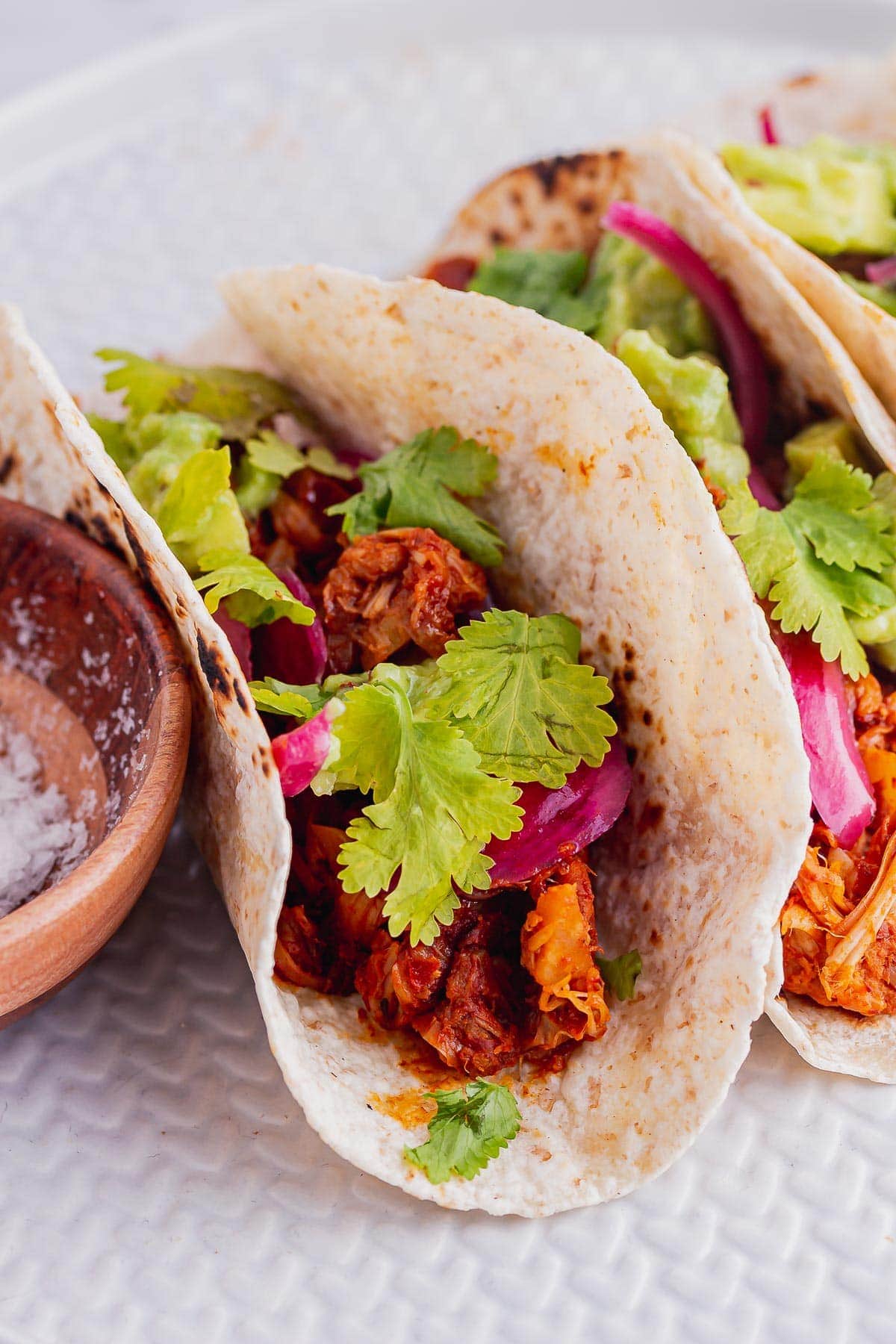 Close up of vegan tacos with jackfruit topped with coriander