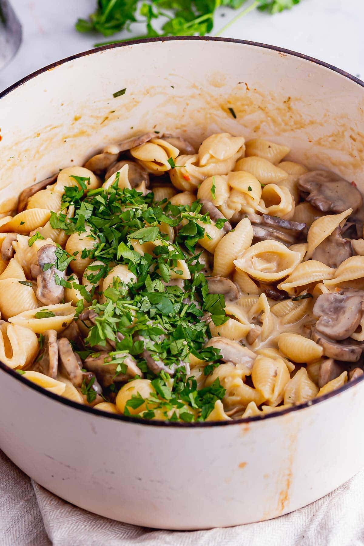 White pot of mushroom stroganoff topped with parsley