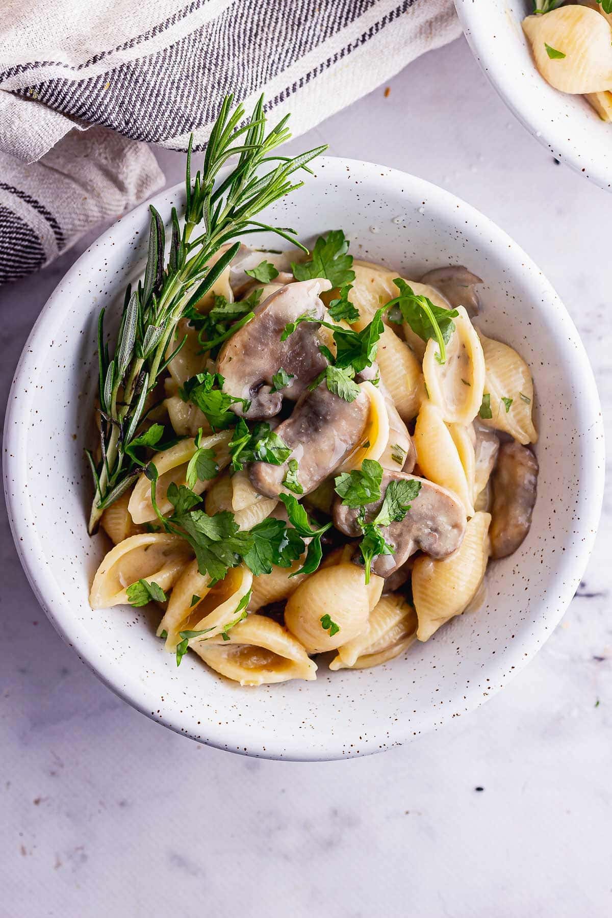 Overhead shot of creamy pasta and mushrooms with herbs