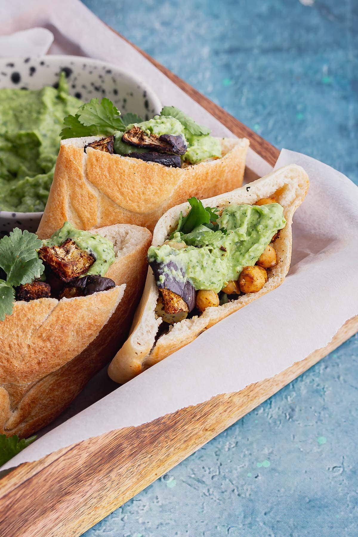 Vegetable sandwiches in a wooden tray on a blue background