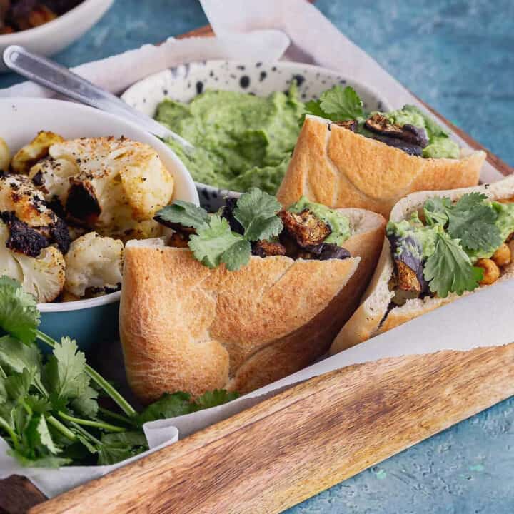 Roasted vegetable sandwiches packed into a tray on a blue surface