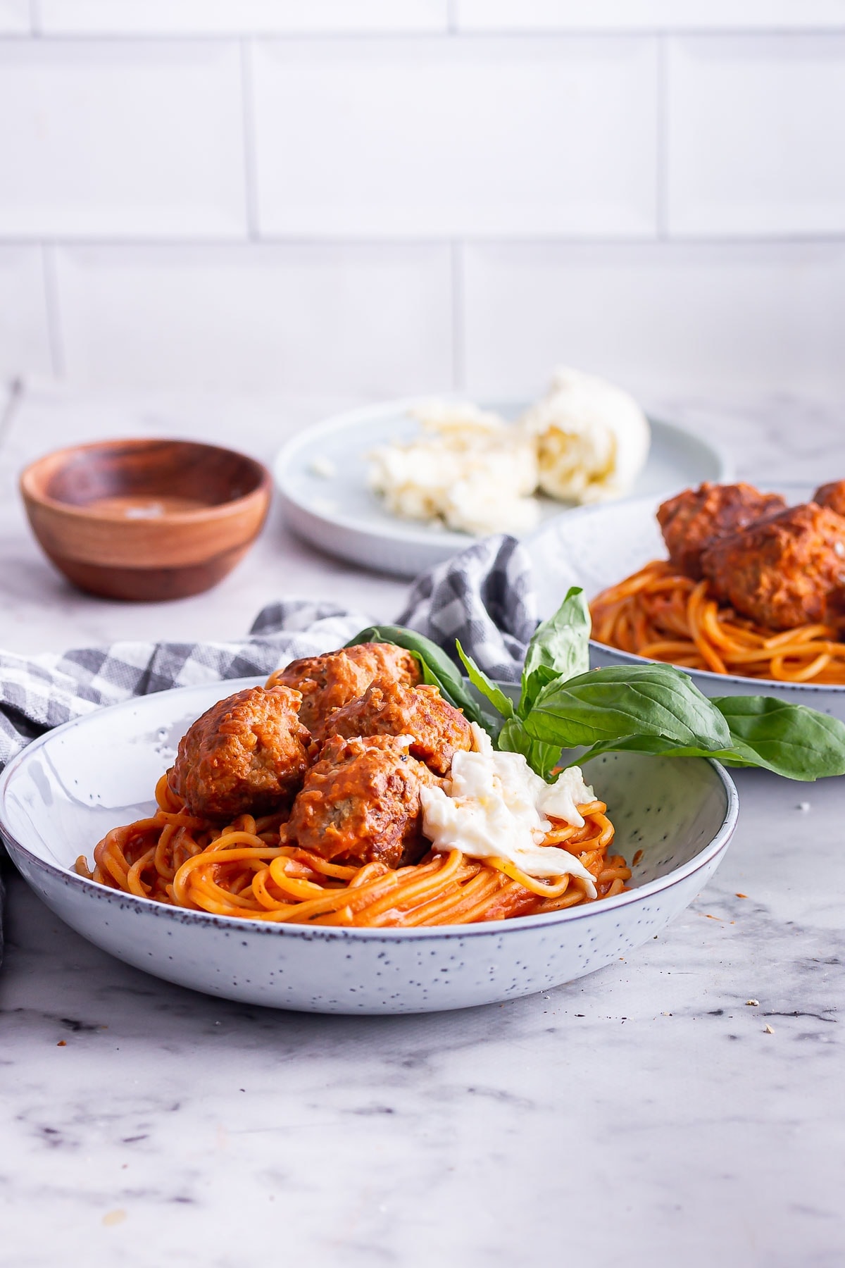 Side on shot of turkey meatballs on spaghetti with tomato sauce