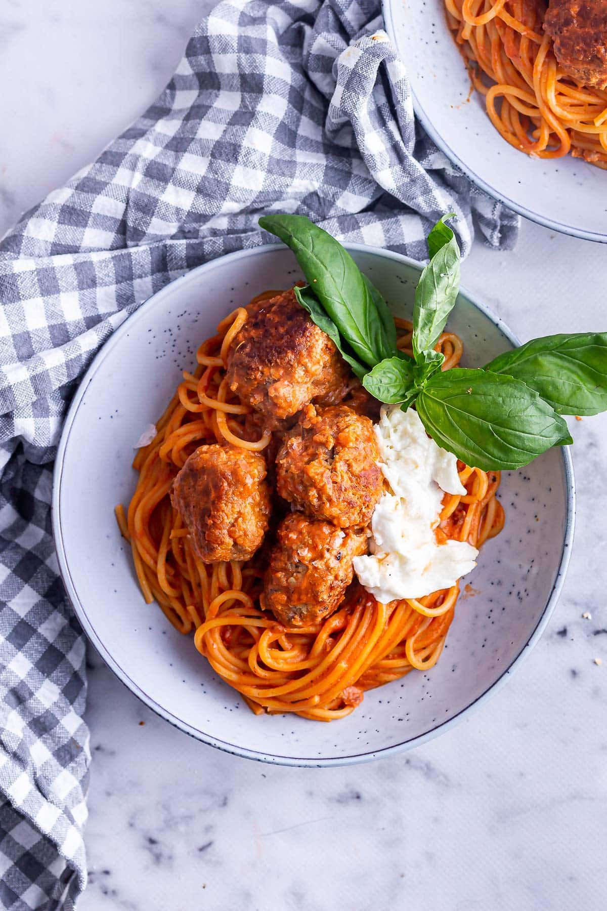 Overhead shot of spaghetti with meatballs with a checked cloth