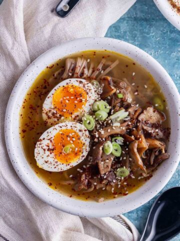 Overhead shot of mushroom miso soup with a boiled egg in a white bowl