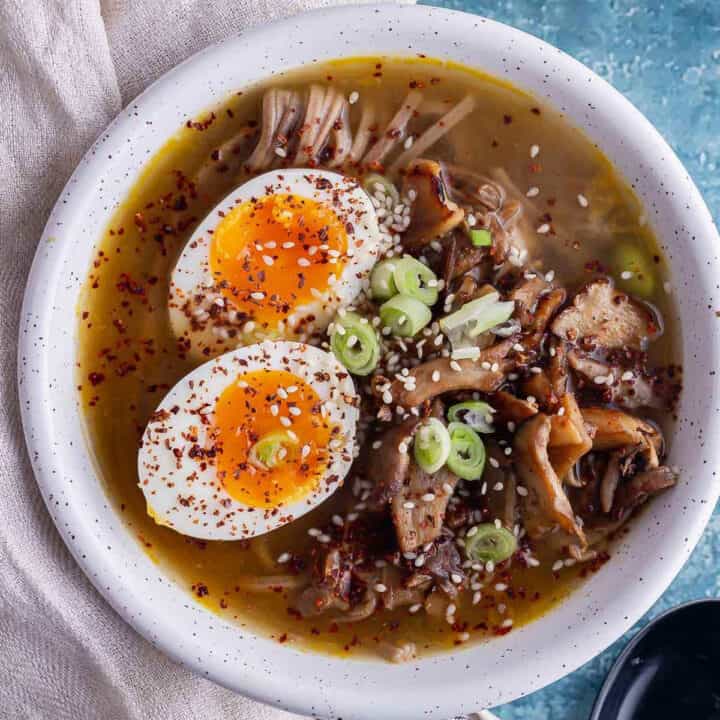 Overhead shot of mushroom miso soup with a boiled egg in a white bowl