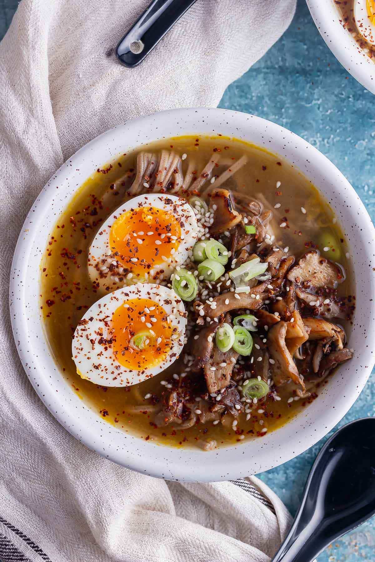 Overhead shot of mushroom miso soup with a boiled egg in a white bowl