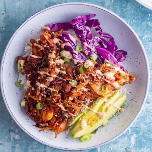 Overhead shot of BBQ jackfruit bowls on a blue surface