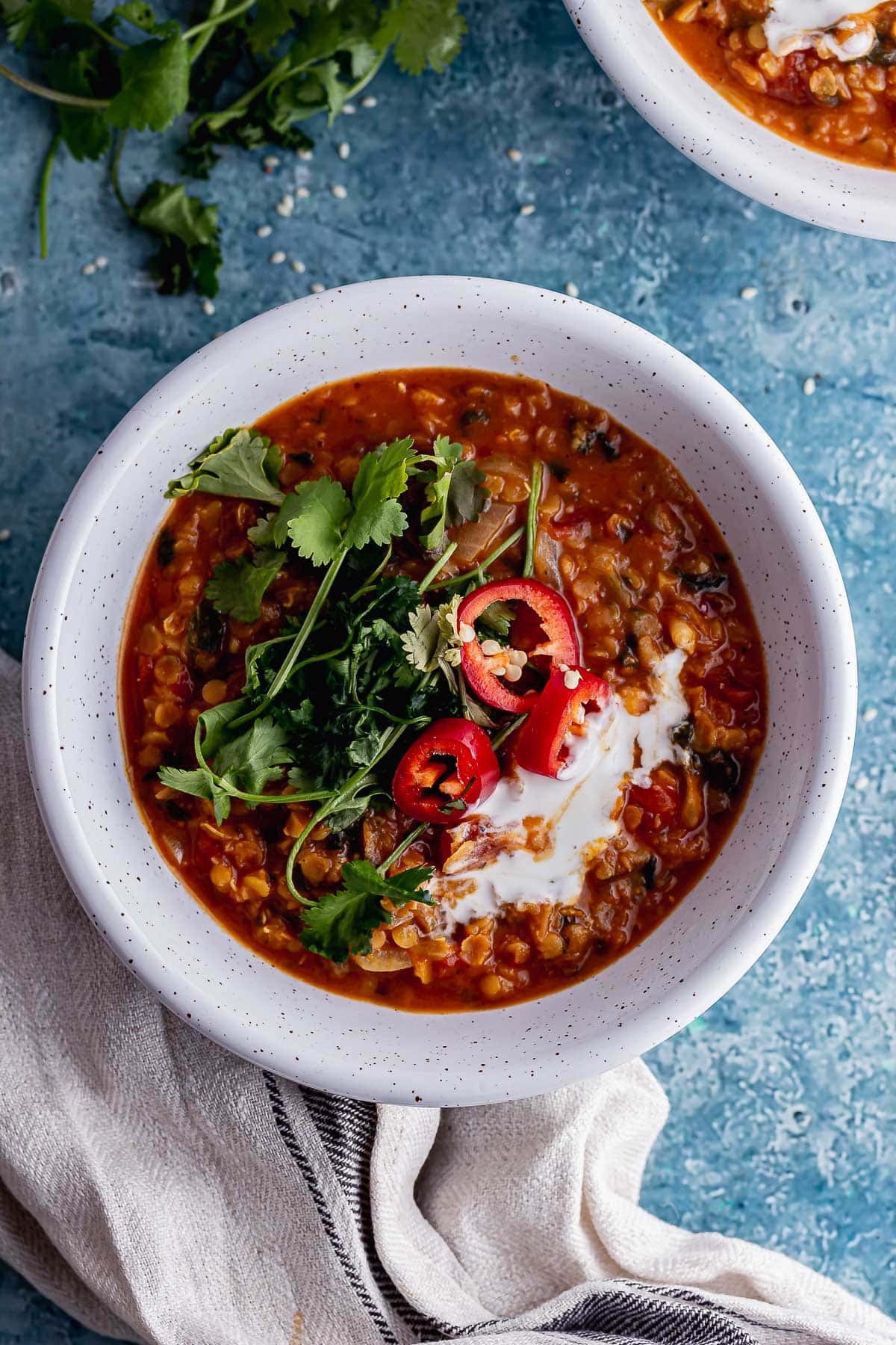 Overhead shot of spicy lentil soup on a blue background