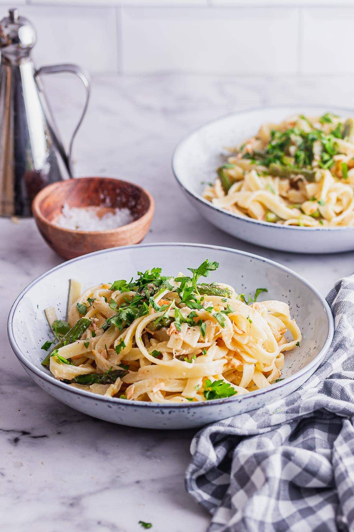 Blue bowl of smoked salmon tagliatelle on a marble background