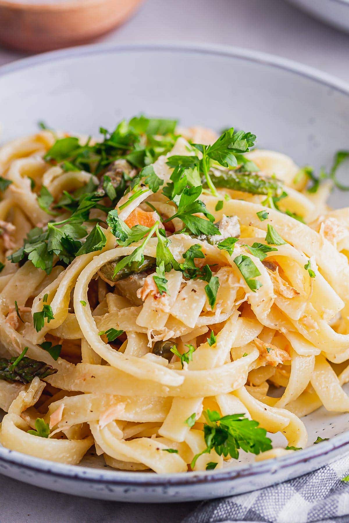 Close up of pasta with smoked salmon topped with parsley