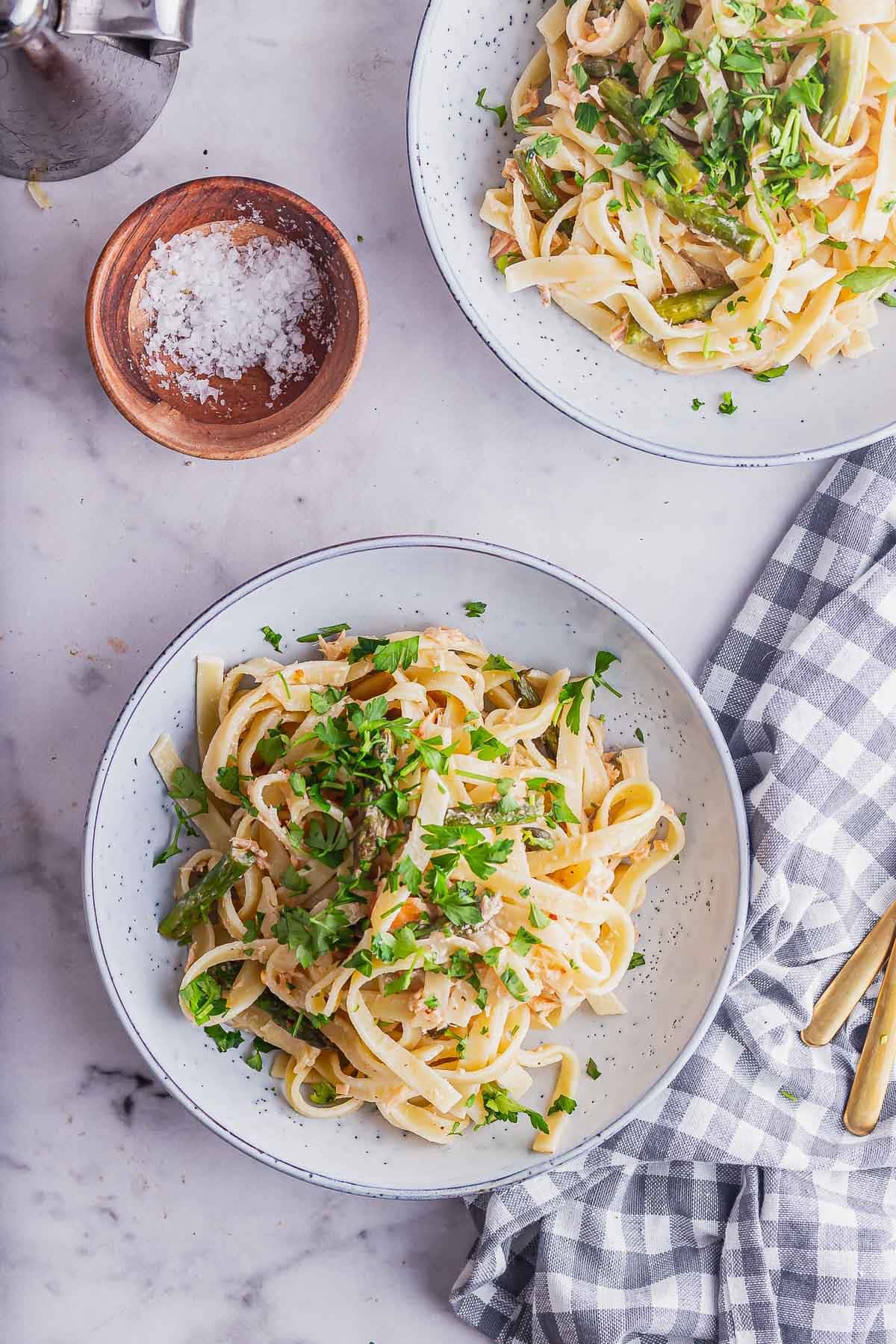 Overhead shot of bowls of smoked salmon pasta on a marble surface