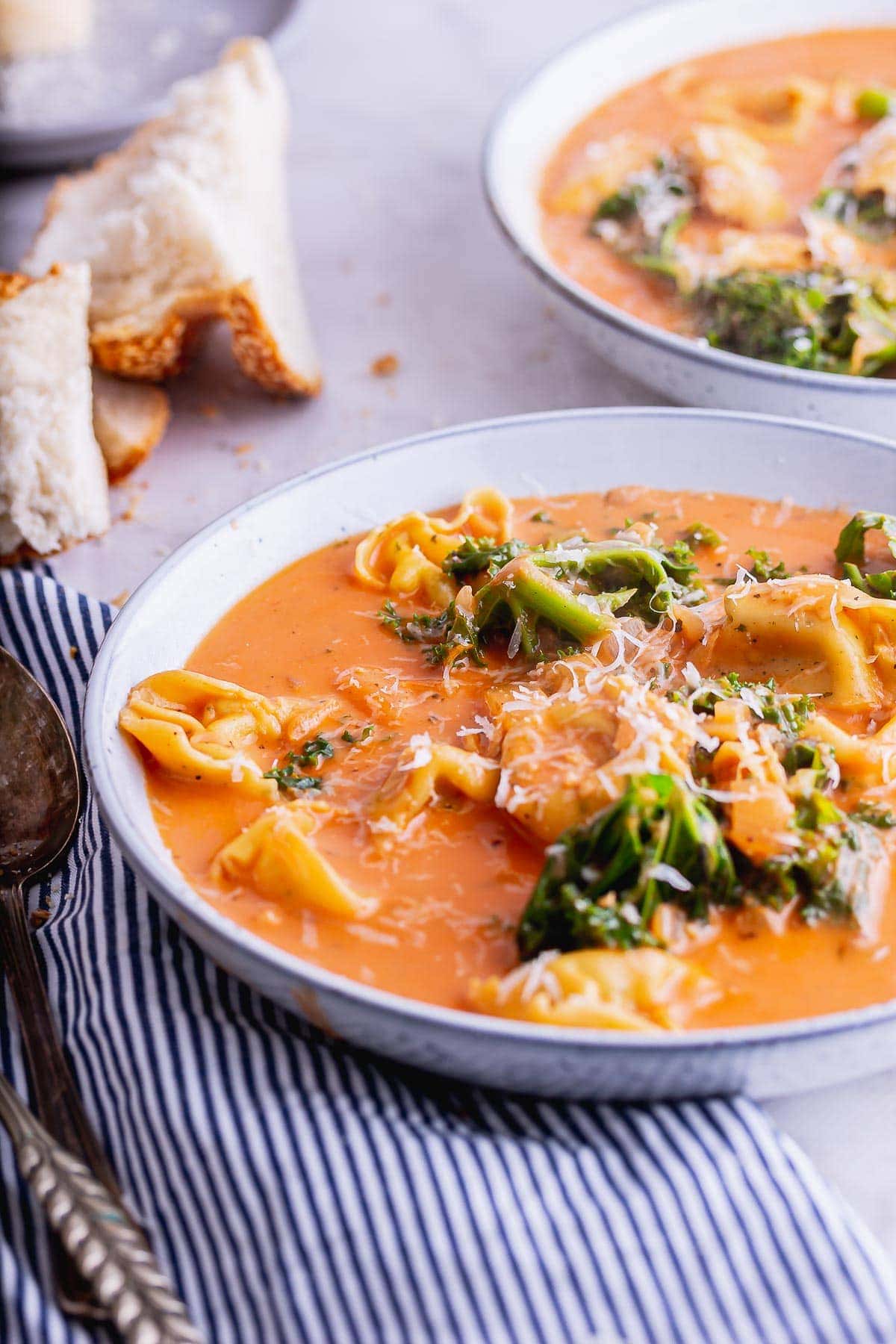 Cheese tortellini in a tomato broth with a striped napkin