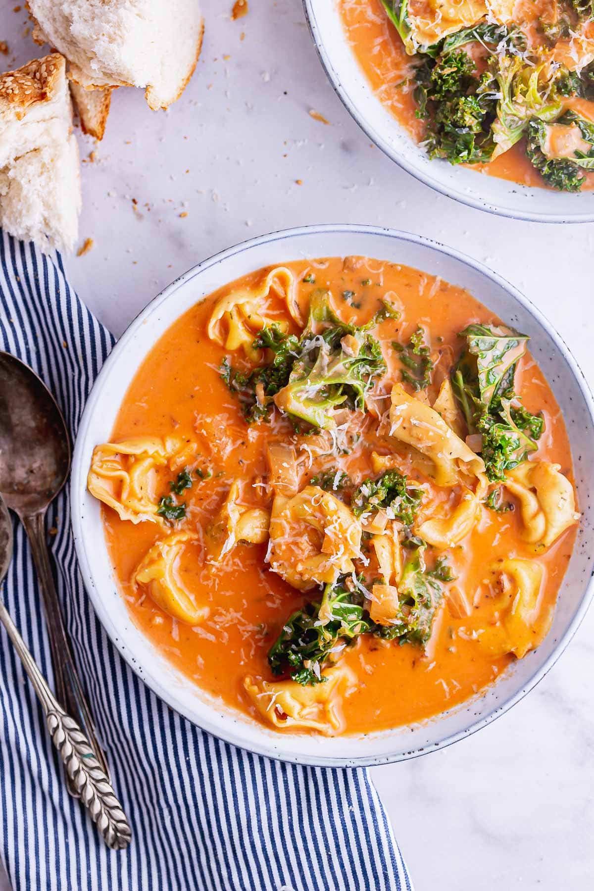 Overhead shot of tortellini soup on a marble background