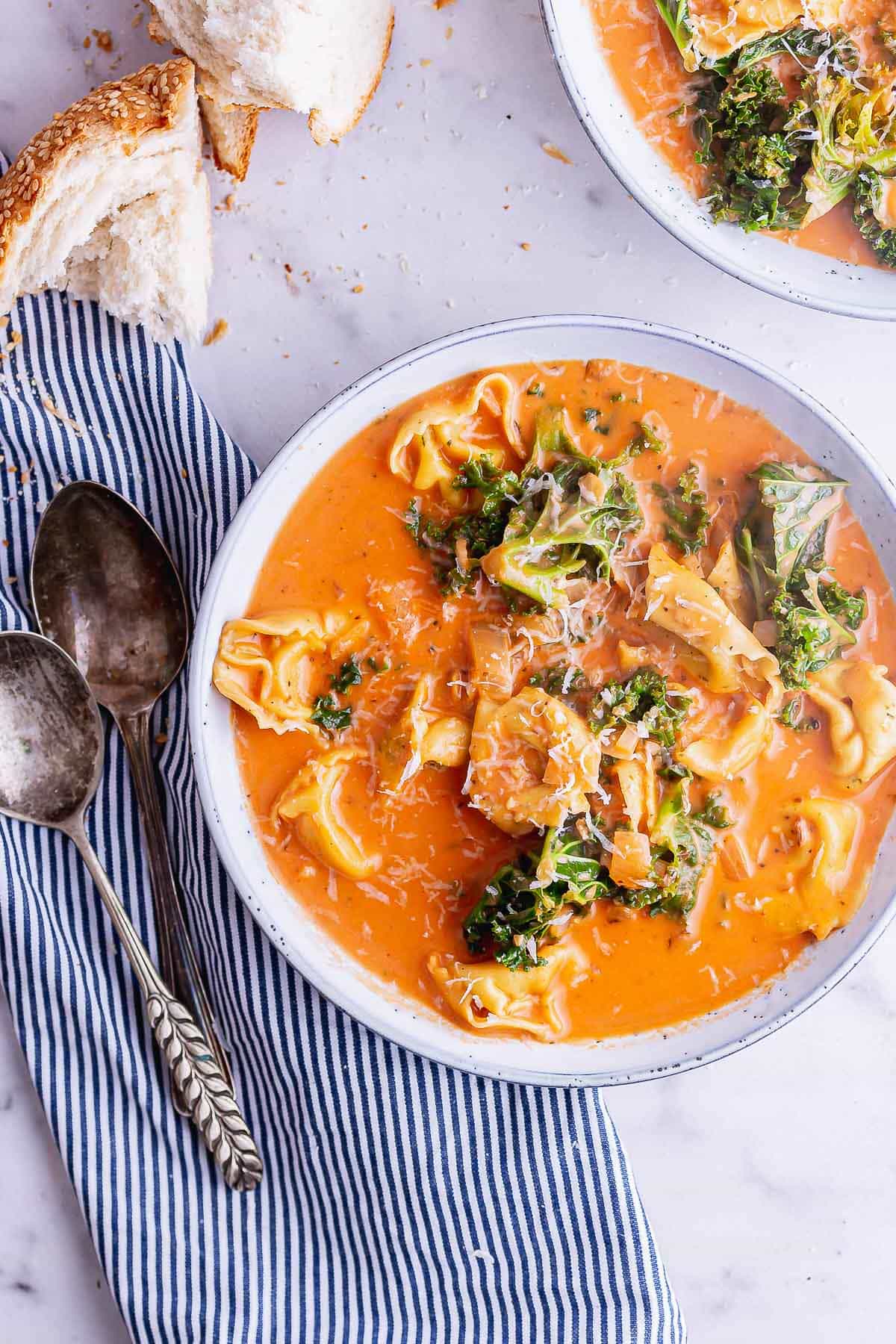 Overhead shot of tortellini soup on a marble surface