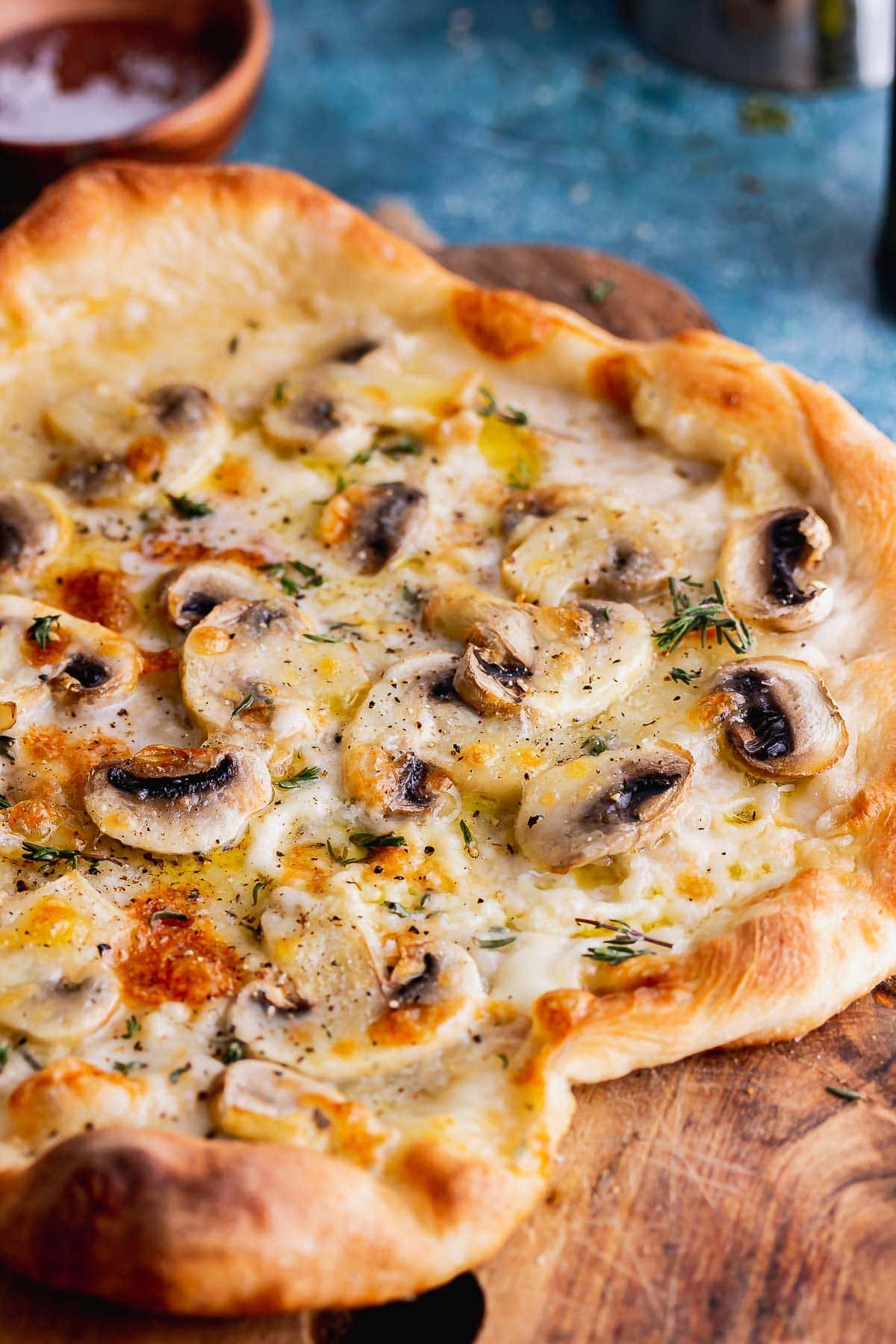 Pizza on a wooden board with a blue background