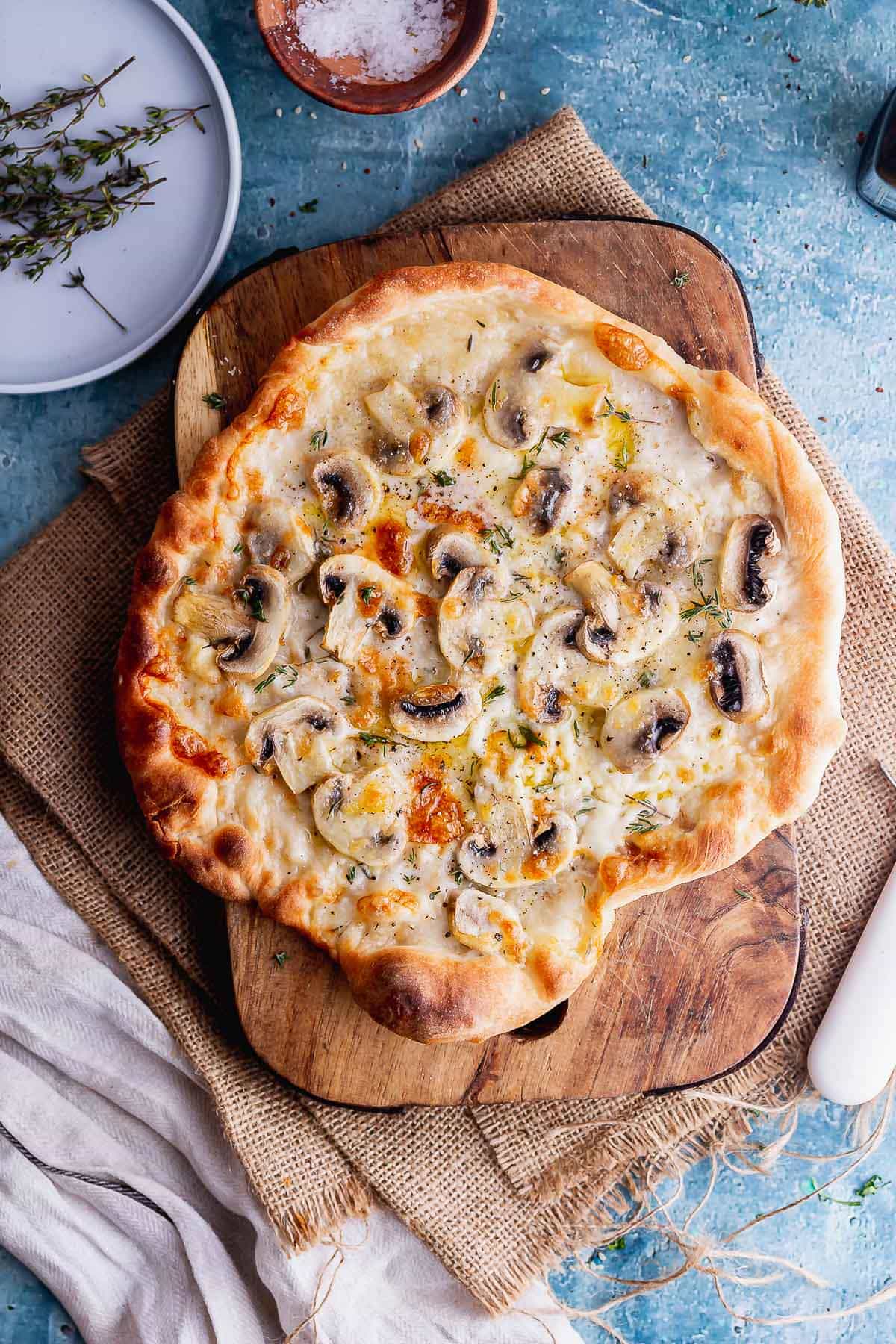 Overhead shot of truffle mushroom pizza on a wooden board