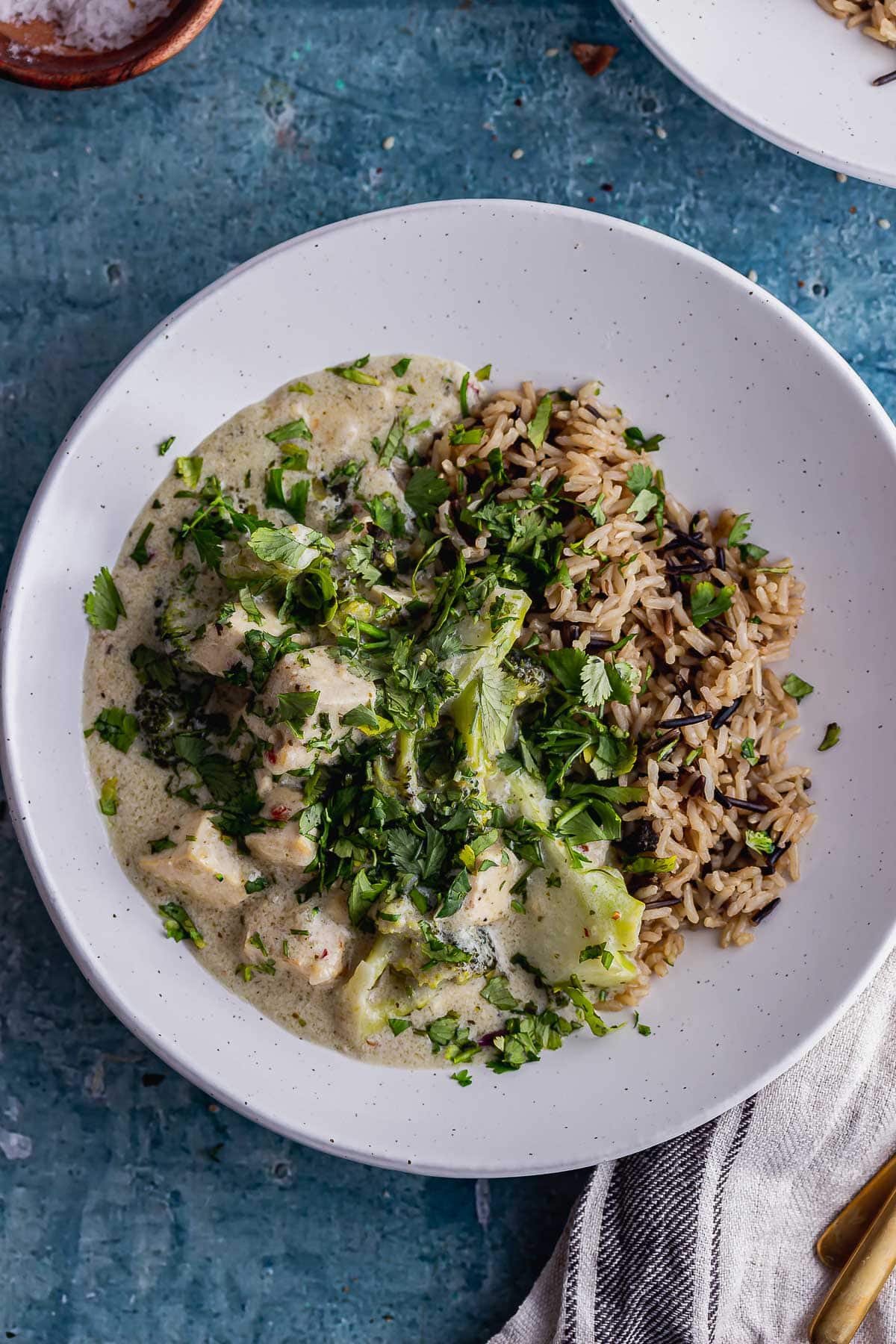 Overhead shot of vegetarian green curry on a blue background